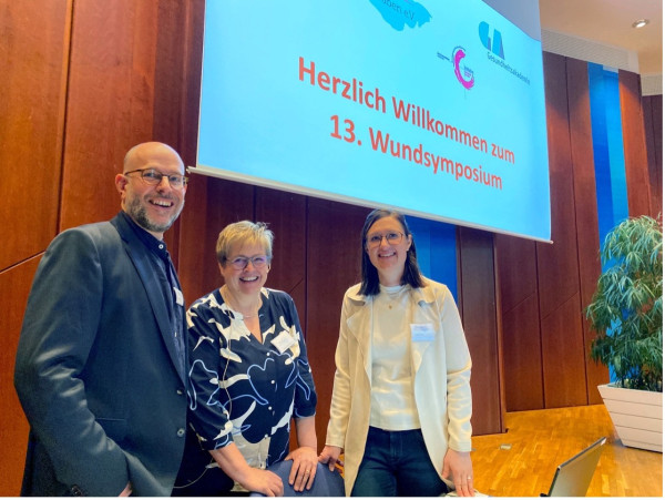&copy; Wundnetz Bodensee-Oberschwaben e.V. | Die Wundnetz-Vorstandsmitglieder Ralf Remmele, Hildegard Kerler und Alissa Nerz (von links) begrüßen 170 Teilnehmende zum 13. Wundsymposium.